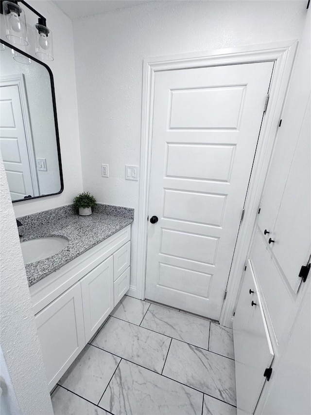 bathroom with marble finish floor and vanity