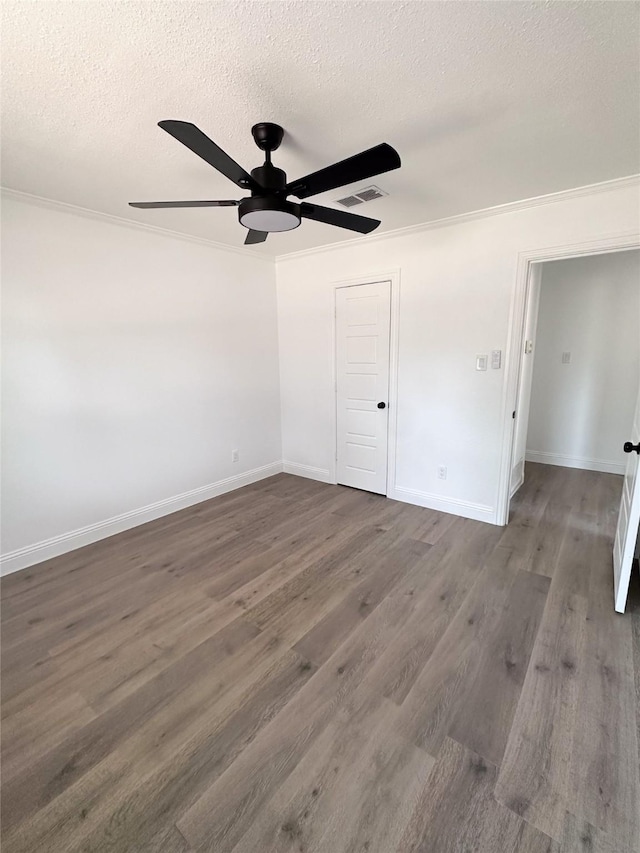 unfurnished bedroom with a textured ceiling, ceiling fan, wood finished floors, visible vents, and baseboards