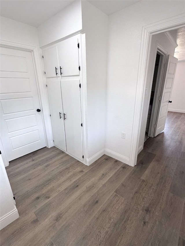 hallway with wood finished floors and baseboards