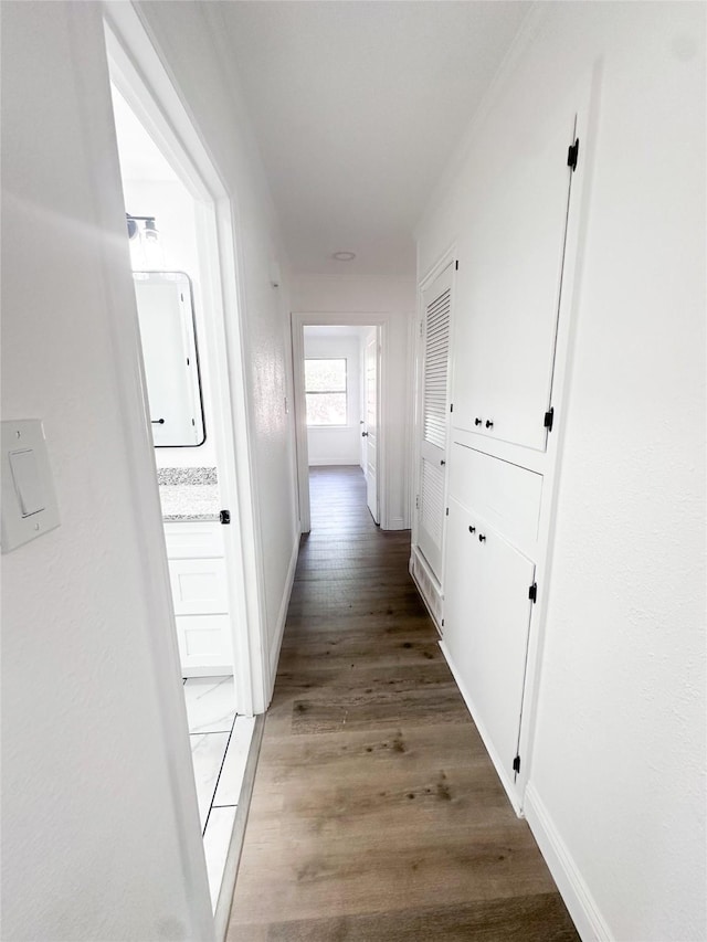 hallway with light wood-type flooring and baseboards