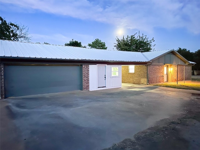 view of front of property featuring metal roof, board and batten siding, and brick siding