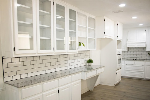 kitchen featuring light stone counters, visible vents, white cabinetry, oven, and black electric cooktop