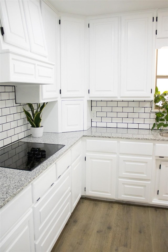 kitchen featuring black electric stovetop, white cabinets, backsplash, custom exhaust hood, and dark wood-style floors