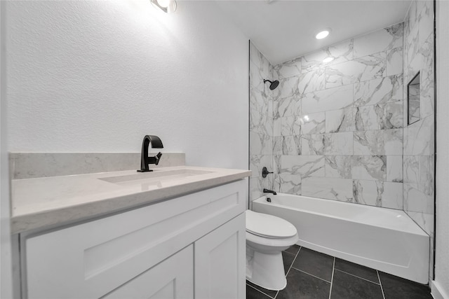 full bathroom featuring a textured wall, tile patterned flooring, toilet, bathtub / shower combination, and vanity