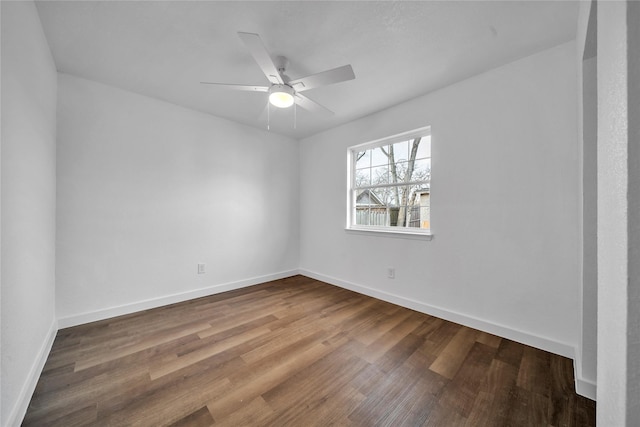 empty room with a ceiling fan, baseboards, and wood finished floors