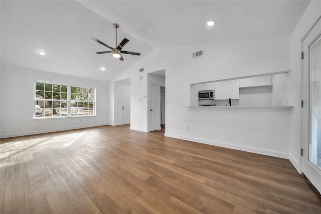 unfurnished living room with baseboards, wood finished floors, visible vents, and a ceiling fan