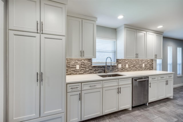 kitchen featuring a sink, white cabinets, light countertops, decorative backsplash, and dishwasher