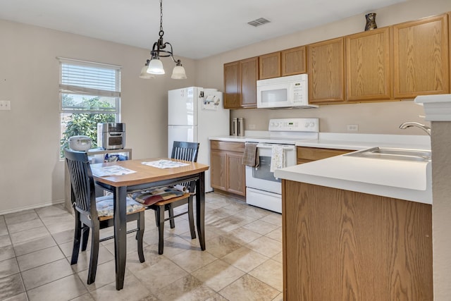 kitchen with white appliances, a sink, visible vents, light countertops, and pendant lighting