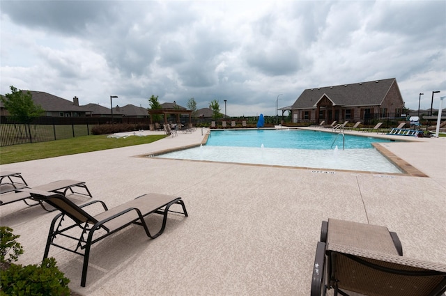 pool with a patio area, fence, a lawn, and a gazebo