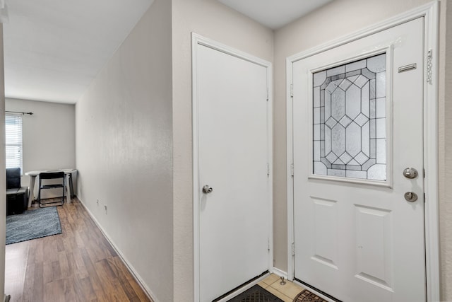 entrance foyer featuring baseboards and wood finished floors