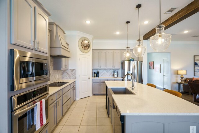 kitchen with premium range hood, ornamental molding, a sink, tasteful backsplash, and appliances with stainless steel finishes