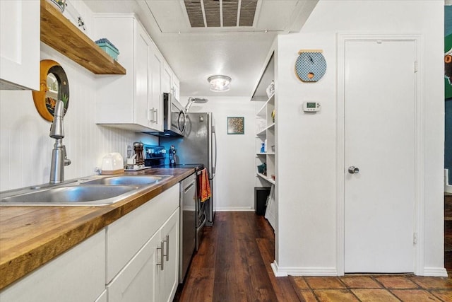 kitchen with open shelves, appliances with stainless steel finishes, visible vents, and white cabinets