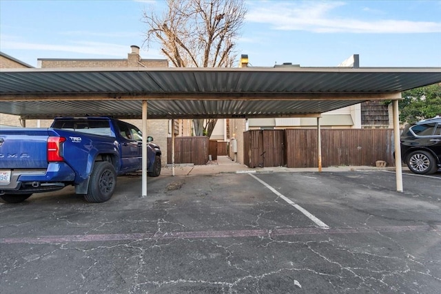 covered parking lot featuring fence