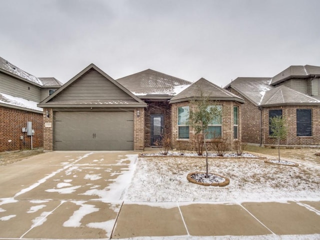 ranch-style home featuring a garage, driveway, and brick siding