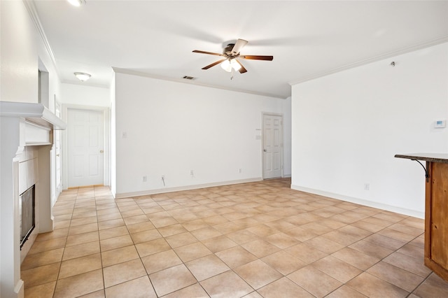 unfurnished living room with crown molding, visible vents, a ceiling fan, a glass covered fireplace, and baseboards