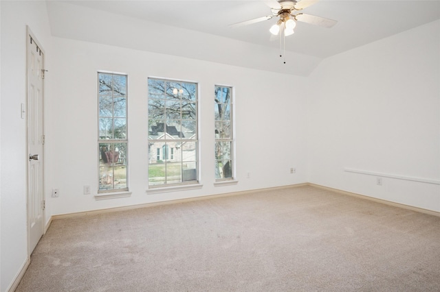 unfurnished room with a ceiling fan, lofted ceiling, light colored carpet, and baseboards