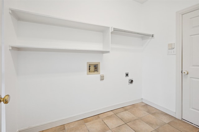 clothes washing area featuring light tile patterned floors, hookup for a washing machine, hookup for an electric dryer, laundry area, and baseboards