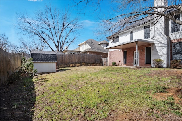 view of yard featuring an outbuilding, a shed, and a fenced backyard