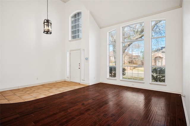 foyer with hardwood / wood-style flooring, plenty of natural light, and high vaulted ceiling