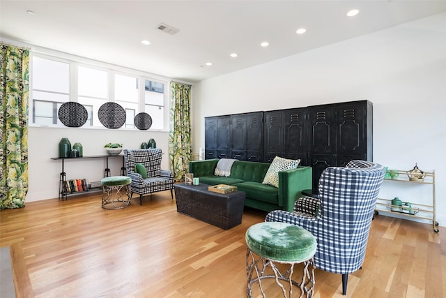 living room with recessed lighting, visible vents, and light wood finished floors