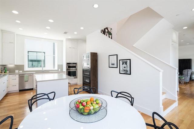 dining space with recessed lighting, stairs, and light wood-style floors