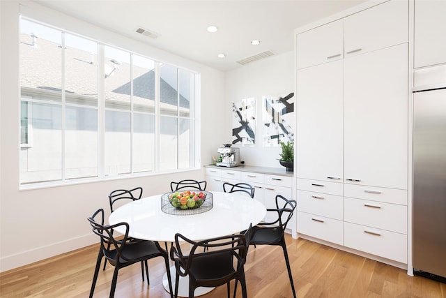 dining room featuring visible vents, a healthy amount of sunlight, and light wood-style floors