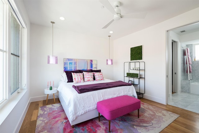 bedroom with recessed lighting, wood finished floors, baseboards, and ensuite bathroom