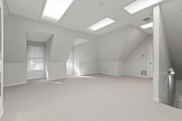 additional living space with carpet, visible vents, vaulted ceiling, and baseboards