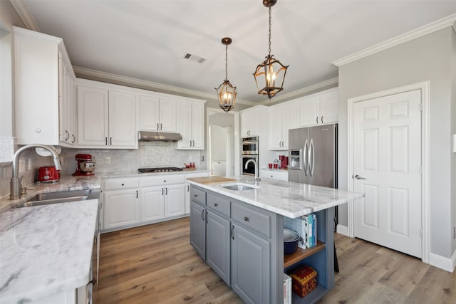 kitchen featuring appliances with stainless steel finishes, white cabinets, visible vents, and a sink