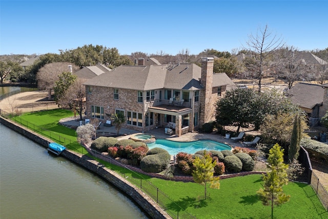 rear view of house featuring stone siding, a patio area, a lawn, and a balcony