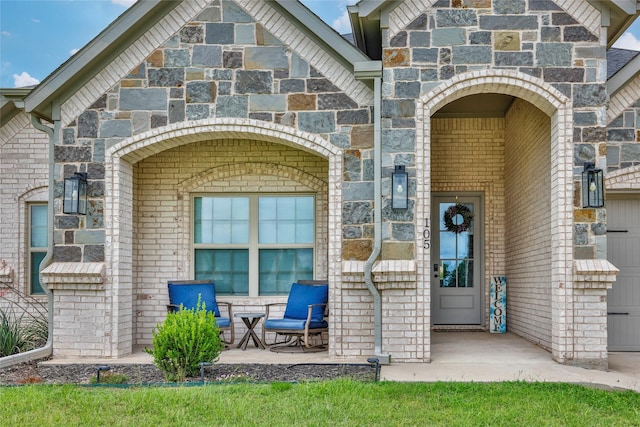 view of exterior entry with stone siding and brick siding