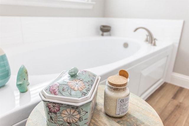 full bathroom featuring wood finished floors and a bath