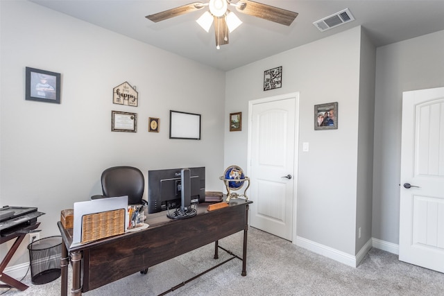 office area featuring a ceiling fan, visible vents, light carpet, and baseboards