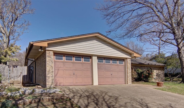 garage with driveway and fence