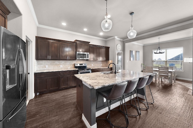 kitchen with dark brown cabinetry, a sink, light stone countertops, stainless steel appliances, and backsplash