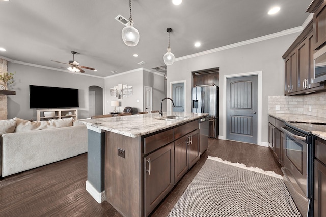 kitchen featuring arched walkways, visible vents, backsplash, appliances with stainless steel finishes, and dark wood-type flooring