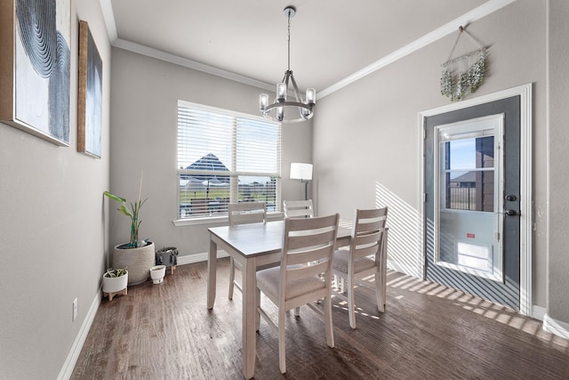 dining room with crown molding, baseboards, wood finished floors, and a notable chandelier