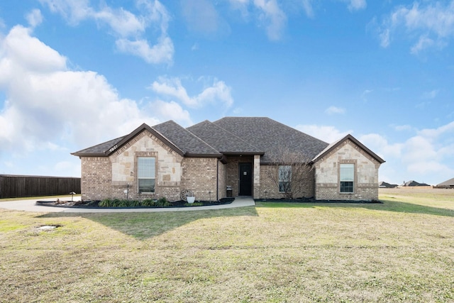 view of front of property with brick siding, a shingled roof, stone siding, and a front yard