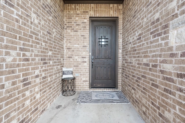 property entrance featuring brick siding