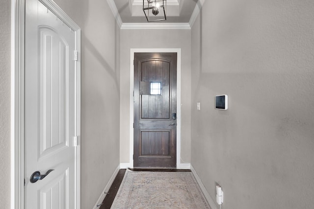 doorway with baseboards, ornamental molding, and wood finished floors