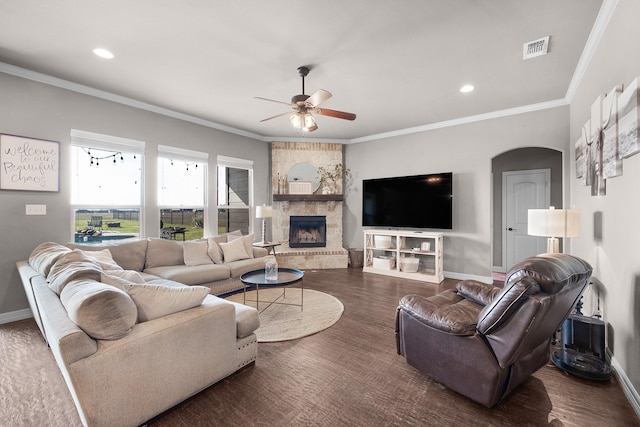 living room featuring baseboards, visible vents, arched walkways, and ornamental molding