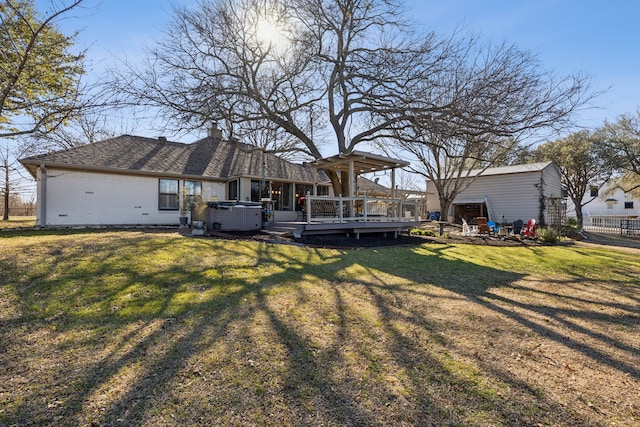 rear view of house featuring a wooden deck, fence, a yard, central air condition unit, and brick siding