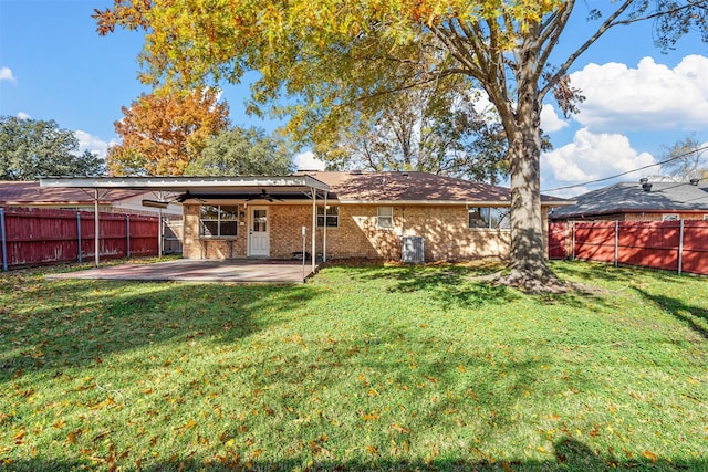 rear view of house with a patio, brick siding, a lawn, and a fenced backyard