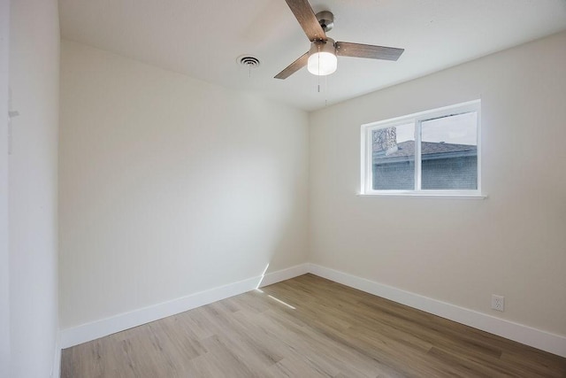 unfurnished room featuring light wood finished floors, baseboards, visible vents, and ceiling fan