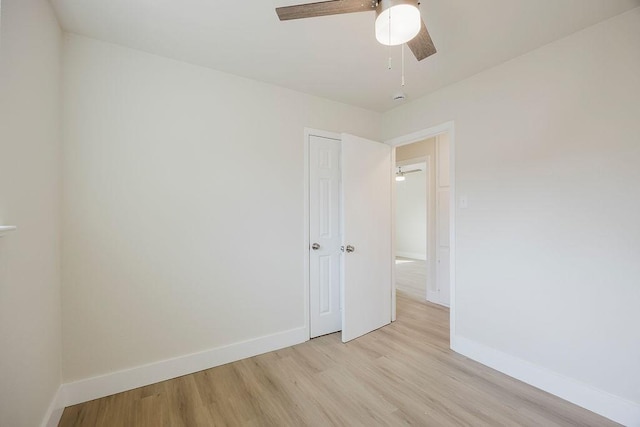 unfurnished room featuring ceiling fan, light wood-type flooring, and baseboards