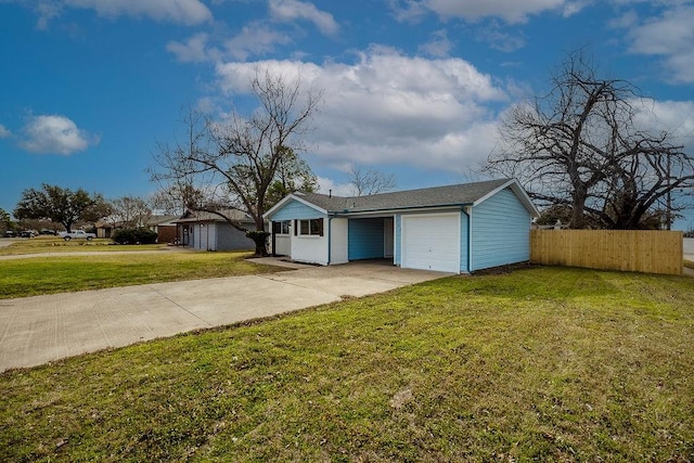 view of front of property with a front lawn, concrete driveway, fence, and an attached garage