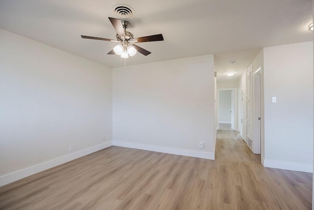 empty room featuring light wood-style floors, visible vents, baseboards, and ceiling fan