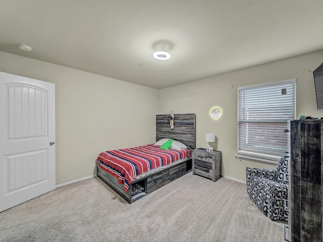 carpeted bedroom featuring a textured ceiling and baseboards