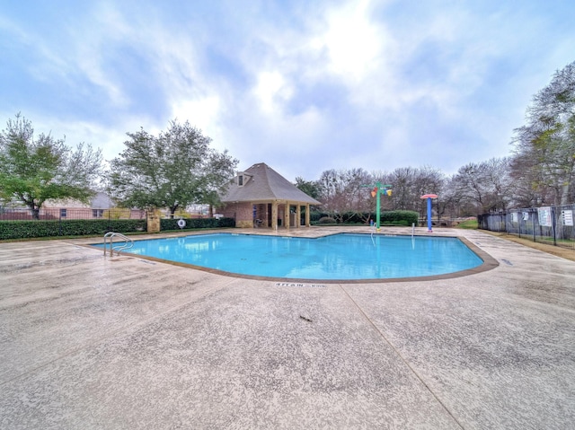 community pool featuring a patio area and fence