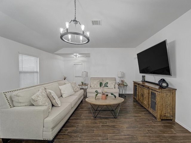 living room with a notable chandelier, lofted ceiling, visible vents, dark wood-type flooring, and baseboards